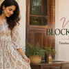 Woman wearing a vintage block print dress in a rustic courtyard